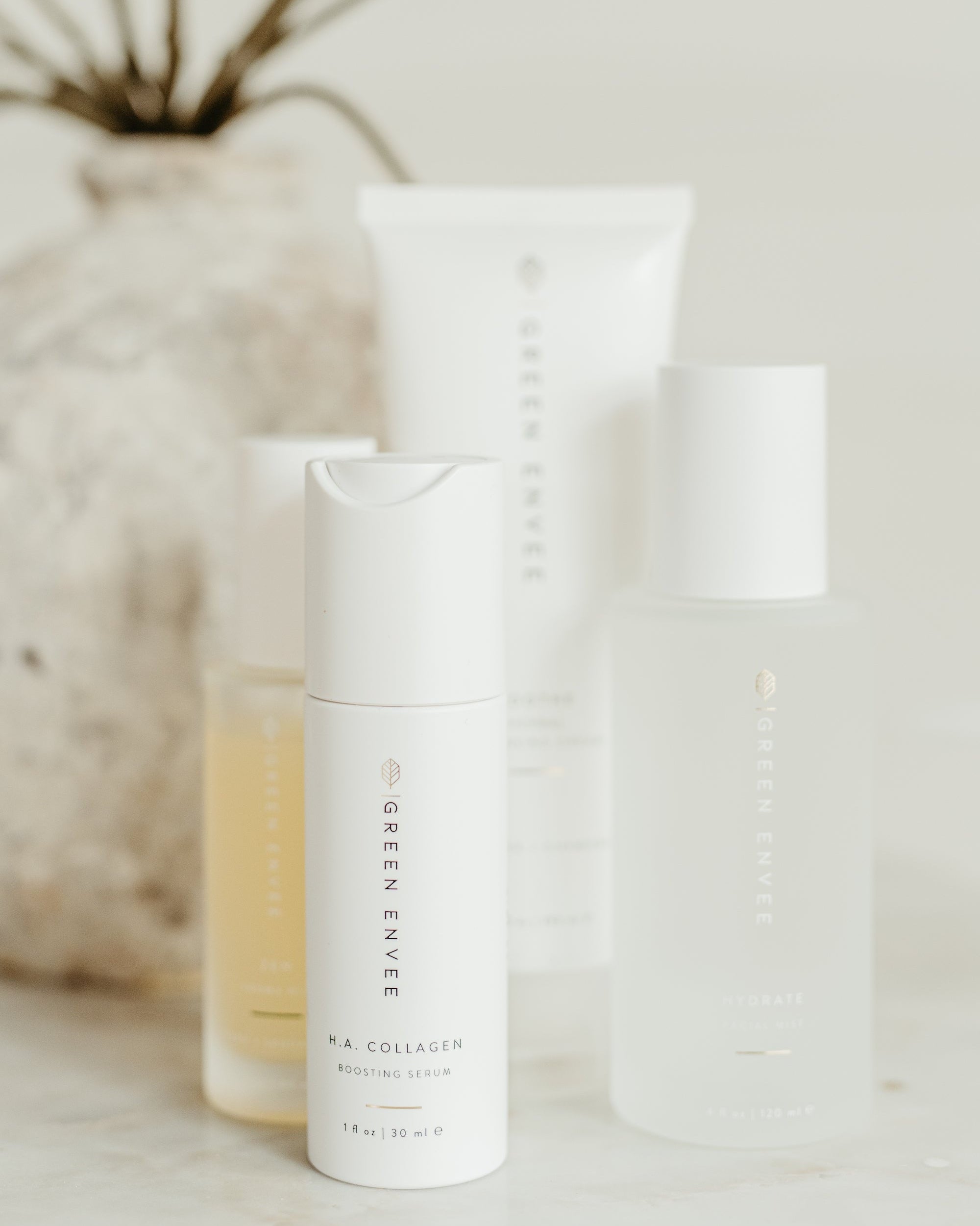 Skincare products on a neutral background with a blurred plant in the background